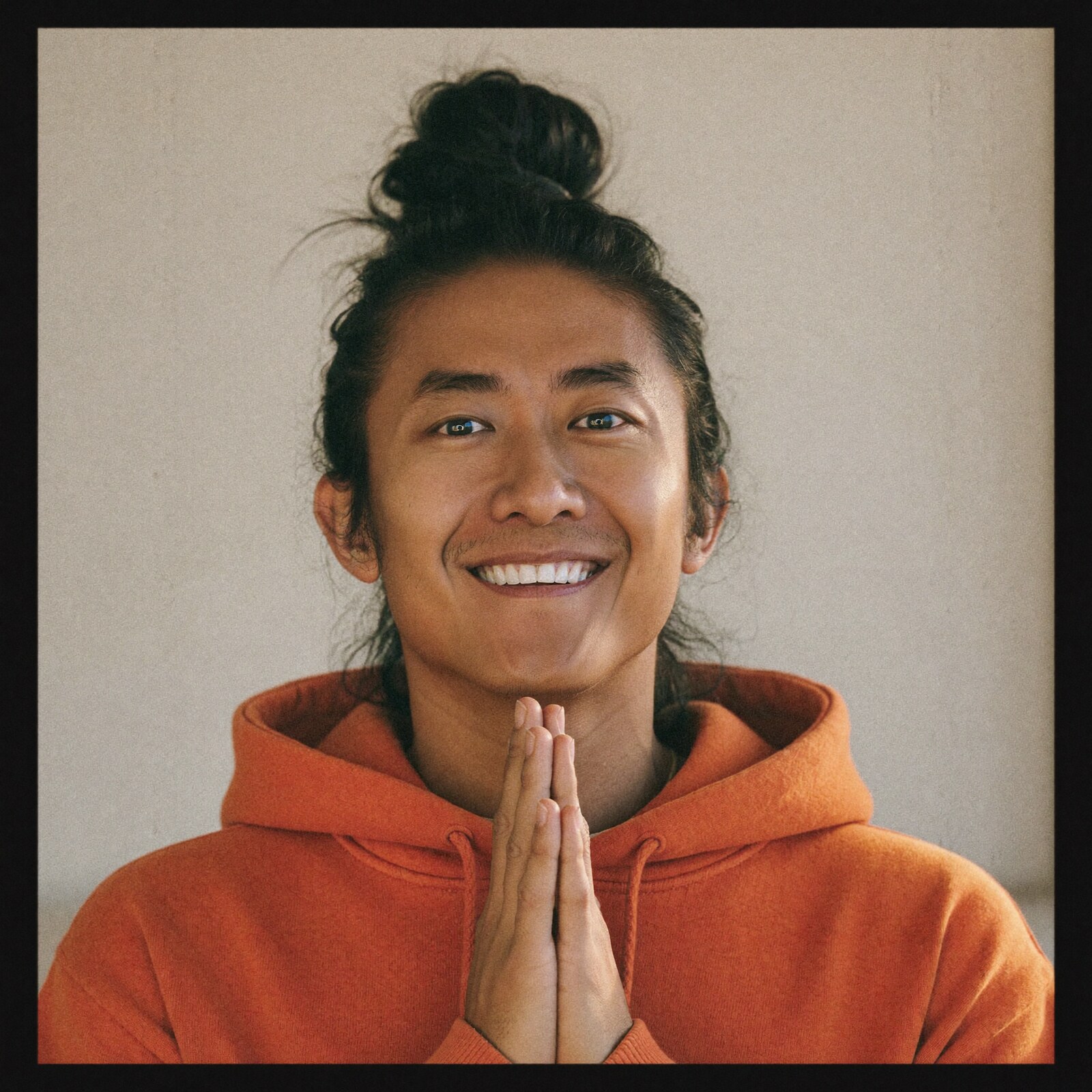 Star Heartsong in an orange hoodie, hands together